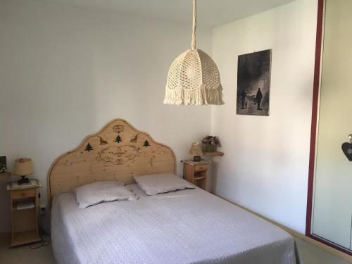 une chambre avec un lit et un lustre dans l'établissement Appartement cosy à Val Cenis Lanslebourg, 300m des pistes, 4/5 personnes, balcon, garage inclus - FR-1-508-62, à Lanslebourg-Mont-Cenis