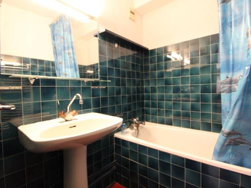 une salle de bain carrelée bleue avec un lavabo et une baignoire dans l'établissement Appartement cosy à Val Cenis Lanslebourg, 300m des pistes, 4/5 personnes, balcon, garage inclus - FR-1-508-62, à Lanslebourg-Mont-Cenis