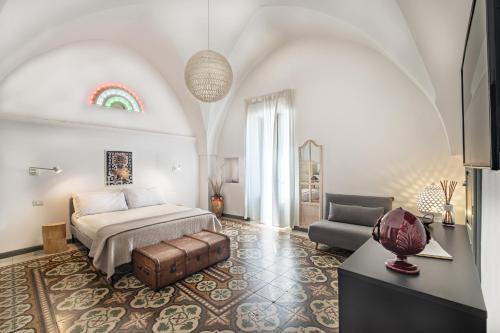 a bedroom with a bed and a couch and a chair at Loft Poerio Ostuni in Ostuni