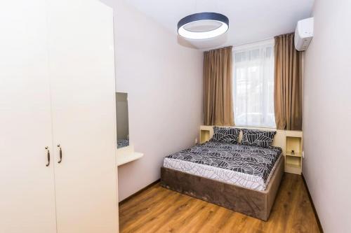 a small bedroom with a bed and a window at Flora Apartment in Burgas City