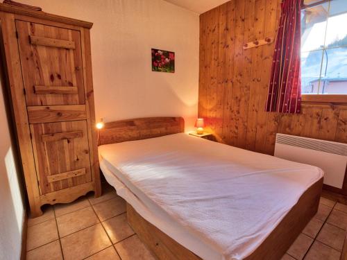 une chambre avec un lit dans une pièce avec une fenêtre dans l'établissement Appartement typique au pied des pistes avec balcon, Wi-Fi, parking - FR-1-505-45, à Notre-Dame-de-Bellecombe