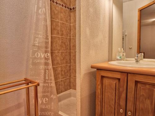 une salle de bain avec un rideau de douche et un lavabo dans l'établissement Appartement typique au pied des pistes avec balcon, Wi-Fi, parking - FR-1-505-45, à Notre-Dame-de-Bellecombe