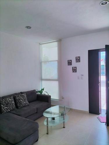 a living room with a couch and a glass table at Casa Bambú in Mérida