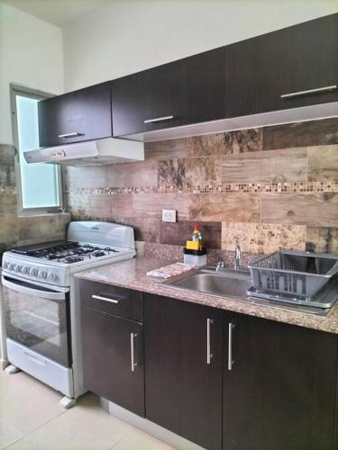 a kitchen with a stove and a sink at Casa Bambú in Mérida