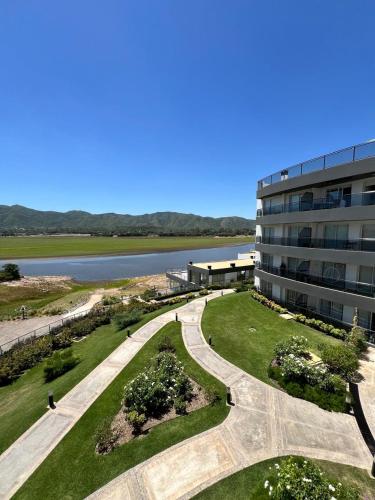 a building with a walkway next to a building at departamento complejo Veneto Village vista al lago in Villa Parque Siquiman