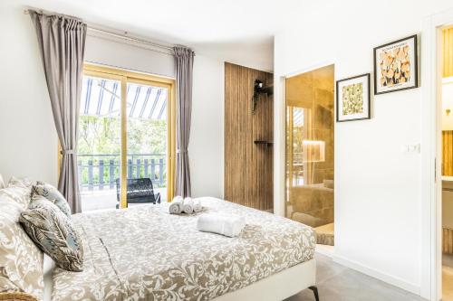 a bedroom with a bed and a large window at GRADO HOUSE-Garden & Hydromassage-Sea-Free Parking in Grado
