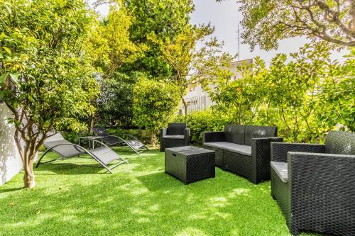 a group of chairs and tables in a yard at GRADO HOUSE-Garden & Hydromassage-Sea-Free Parking in Grado