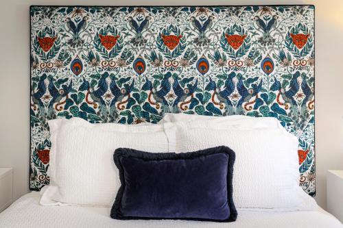 a bed with a headboard with a blue and white pillow at The West Lane Inn in Ridgefield