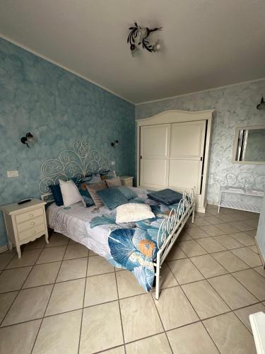 a bedroom with a bed with a blue wall at La Cascina della Vachina in Poggio Bustone
