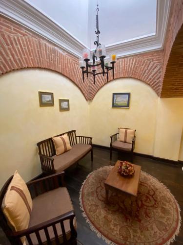 a living room with chairs and a table and a chandelier at Casa Noble Hotel in Antigua Guatemala