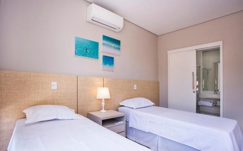 a bedroom with two beds and a lamp in it at Residencial Marina Del Sol in Pauba