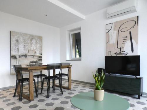 a living room with a table and chairs and a tv at Il Piccolo Convento- NUOVA GESTIONE 2025- in La Spezia