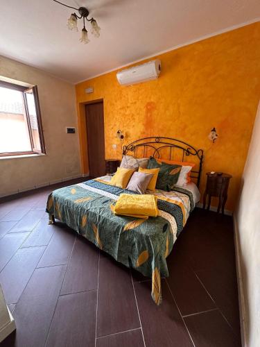 a bedroom with a bed and a yellow wall at La Cascina della Vachina in Poggio Bustone