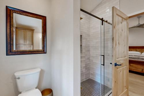 a bathroom with a toilet and a mirror at Two Bit Cabin in Deadwood