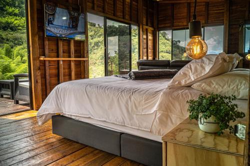 a bedroom with a bed in a room with windows at El Indio EcoLodge in El Amparo