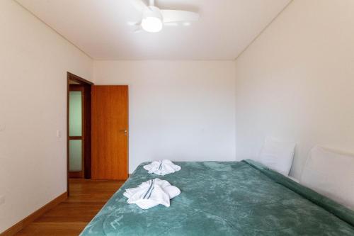 a bedroom with a bed with two towels on it at Pousada Cantareira - Suítes na Serra da Cantareira in Mairiporã