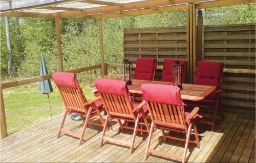 a wooden table and chairs on a deck at Amazing Home In Annerstad With Sauna in Romborna