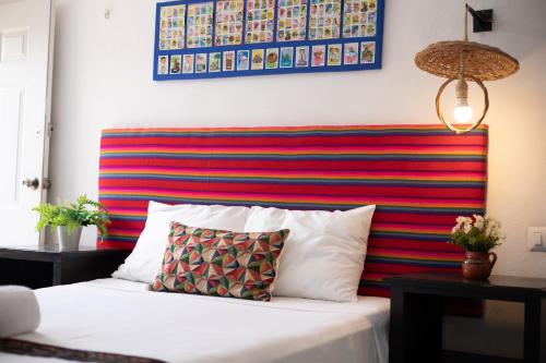 a bed with a colorful headboard with a pillow on it at Departamentos privados In Wotoch in Valladolid
