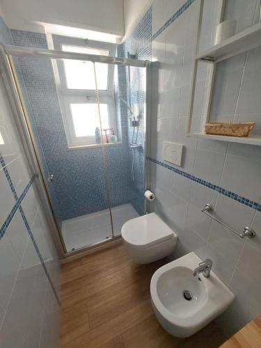 a bathroom with a toilet and a shower and a sink at Blue Sea Apartment in Torre Canne