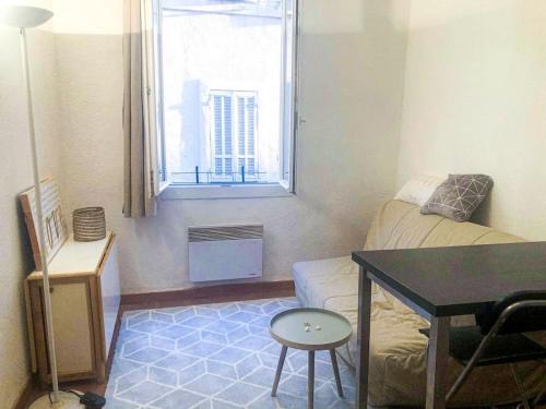 - un petit salon avec une table et une fenêtre dans l'établissement Retraite provençale, charmant studio en cœur de ville, à Aix-en-Provence