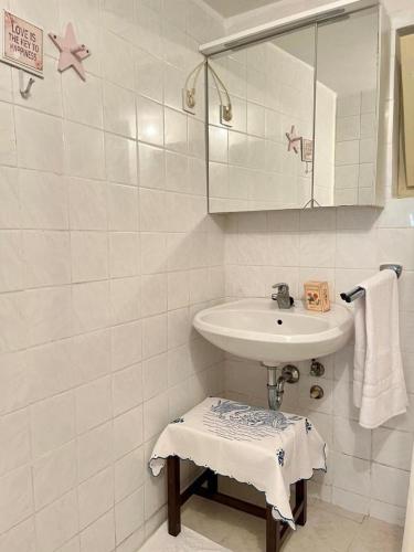 a white bathroom with a sink and a mirror at Vila Klara in Olib