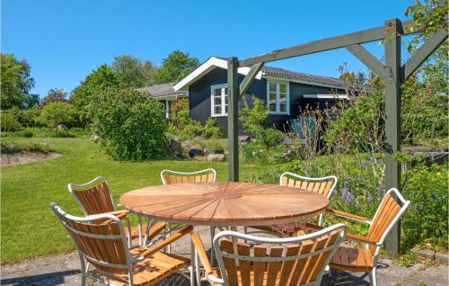a wooden table and chairs in a yard at 2 Bedroom Amazing Home In Tisvildeleje in Tisvildeleje