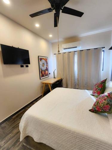 a bedroom with a large bed with a ceiling fan at Departamento con Terraza in La Paz