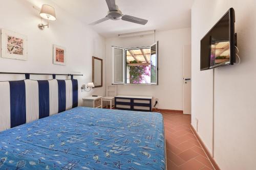 a bedroom with a blue bed and a window at Villino Lampone - Goelba in Lacona
