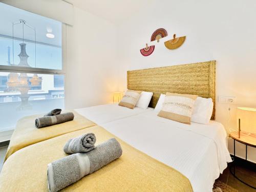 two beds in a bedroom with a large window at Casa Natura Arena Beach in Puerto Marino