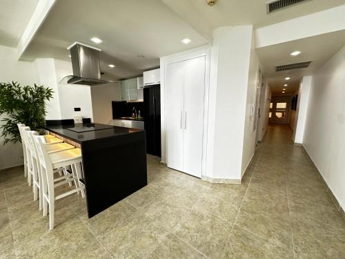 a kitchen and dining room with a black counter and chairs at Beachfront apartament in Juan Dolio in Juan Pedro