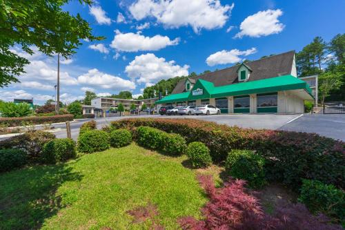 a building with a green roof and a parking lot at Budgetel Inn and Suites in Atlanta