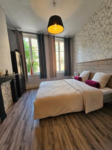 - une chambre avec un grand lit et une lampe pendant dans l'établissement Nid nature et douceur à Eu - Proche du Treport et de la Baie de Somme, à Eu