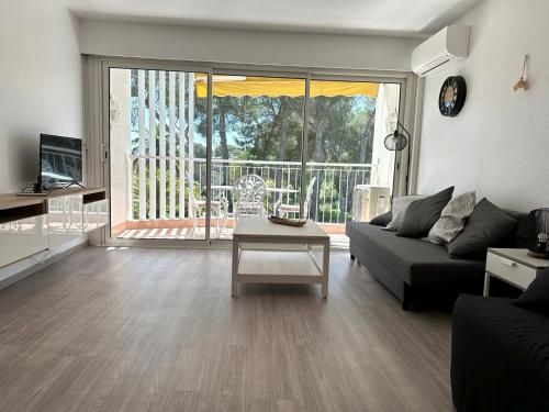 un salon avec un canapé et une table dans l'établissement le boreal bord de mer avec piscine, à Saint-Raphaël