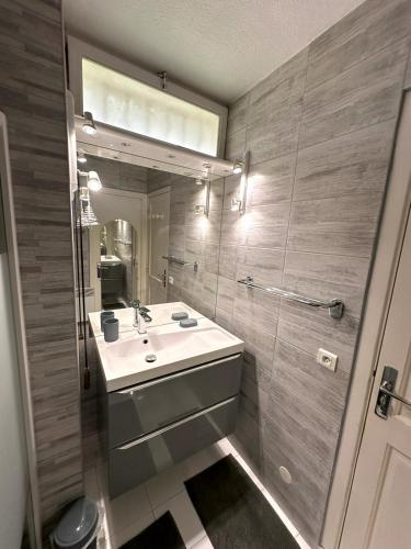 une salle de bain avec un lavabo et un miroir dans l'établissement le boreal bord de mer avec piscine, à Saint-Raphaël