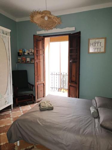 a bedroom with a bed and a chair and a window at Plaça de l'Almudí, where else! in Onda