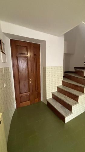 an empty room with stairs and a wooden door at Il borgo di Mefila, La casa del Ruto in Scandriglia
