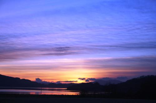 a sunset over a body of water with the sky at Melfort House in Kilmelfort