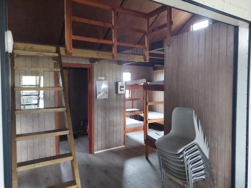 a room with bunk beds and a chair and a ladder at Fremstaver in Blaskogabyggo