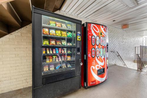 a soda vending machine is next to a refrigerator at Budgetel Inn and Suites in Atlanta