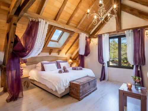 Un dormitorio con una cama en una habitación con techos de madera. en Domaine de Campagnac - Spa & Sauna, en Carsac-Aillac