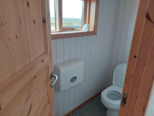 a bathroom with a toilet and a window and a door at Fremstaver in Blaskogabyggo