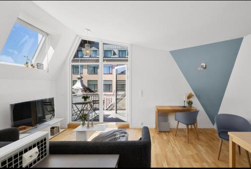 a living room with white walls and a large window at Stavanger juvel in Stavanger
