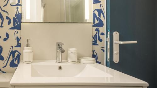 a bathroom with a white sink and a mirror at BonAppart 12 - Charme Napoléonien & Confort in Troyes