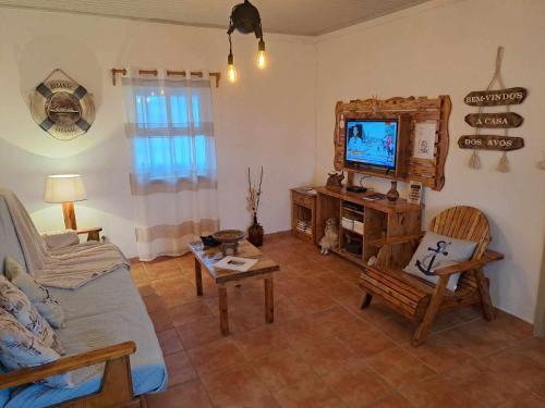 a living room with a couch and a tv at A Casa dos Avós in Lajes das Flores