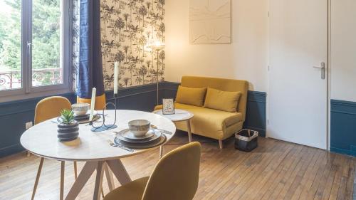 un salon avec une table et une chaise dans l'établissement BonAppart 12 - Charme Napoléonien & Confort, à Troyes
