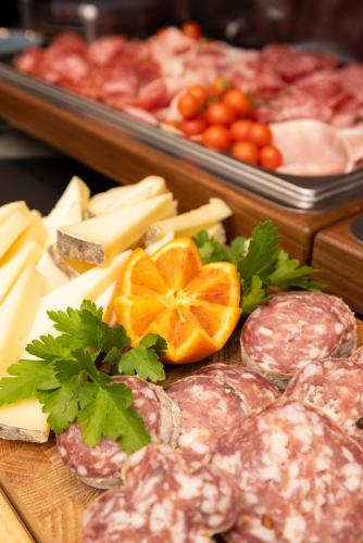 a display of meats and cheeses on a cutting board at Hotel Indigo Turin by IHG in Turin