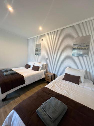 two beds in a hotel room with two beds sidx sidx sidx at Hotel Mackenna in Osorno