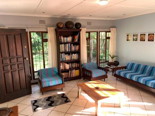 a living room with a couch and chairs and a table at Peace Cottage in St Lucia