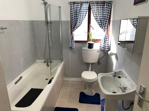 a bathroom with a tub and a toilet and a sink at Peace Cottage in St Lucia
