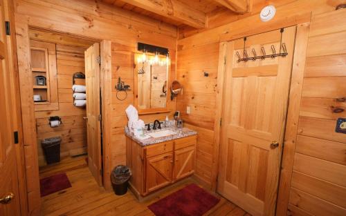 a bathroom with a sink in a wooden cabin at Chardonnay Getaway in Pigeon Forge